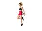 Femme en brassière de sport noire et short rouge sautant avec des haltères.
