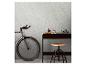 Vélo et bureau avec objets décoratifs contre un mur texturé.