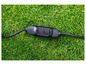 Un câble d'extension noir avec des boutons de test et de réinitialisation sur l'herbe.