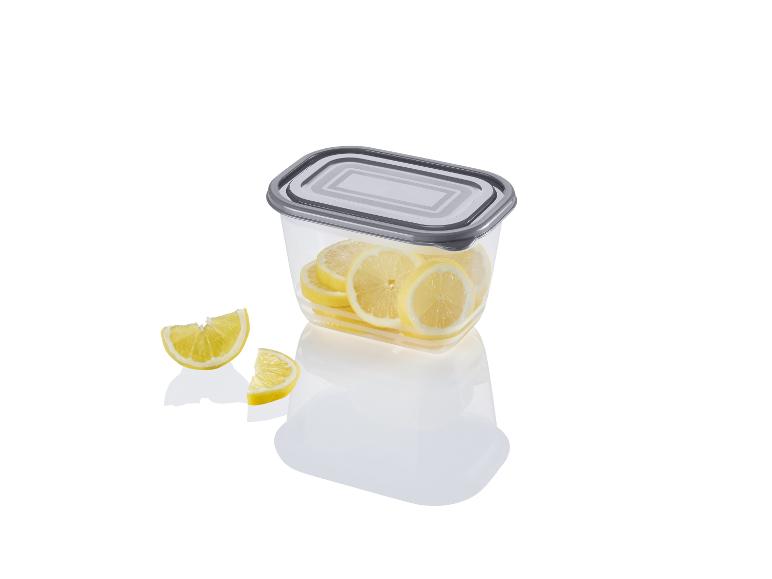Une boîte de rangement en plastique transparent avec un couvercle gris rempli de tranches de citron.