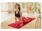 Femme faisant du yoga sur un tapis rouge.