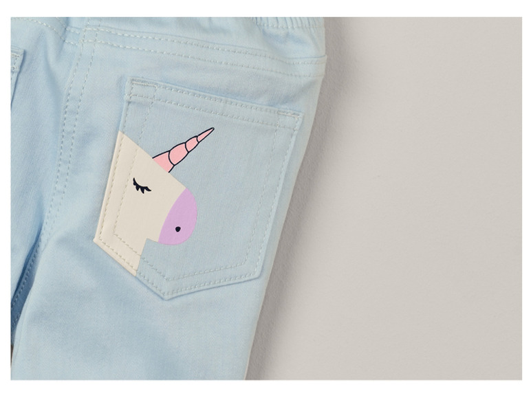 Un jean bleu clair avec une licorne sur la poche arrière.