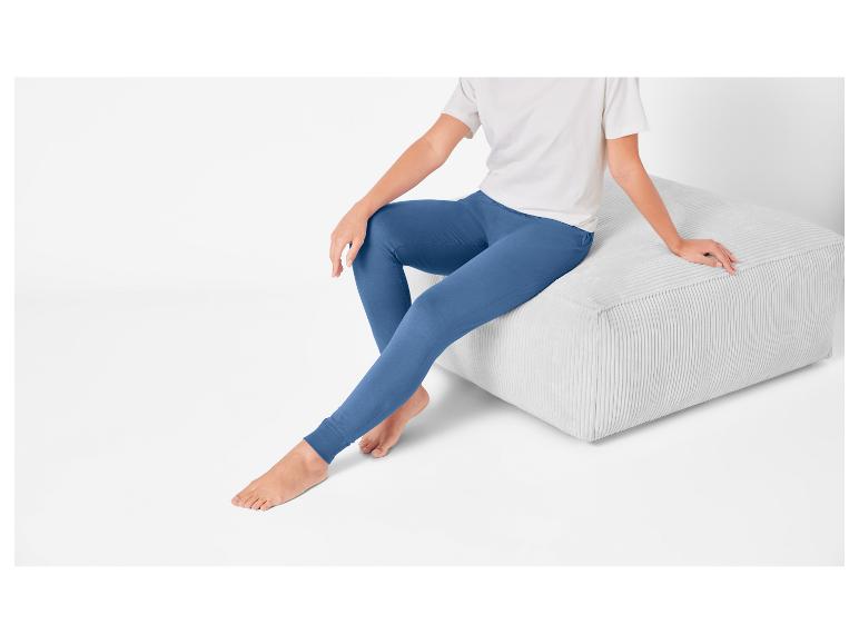 Leggings bleus et pouf en velours côtelé gris clair.