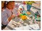 Une fille construit un set LEGO de fleurs dans un pot.