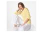 Femme en t-shirt jaune à manches longues et pantalon blanc, assise.