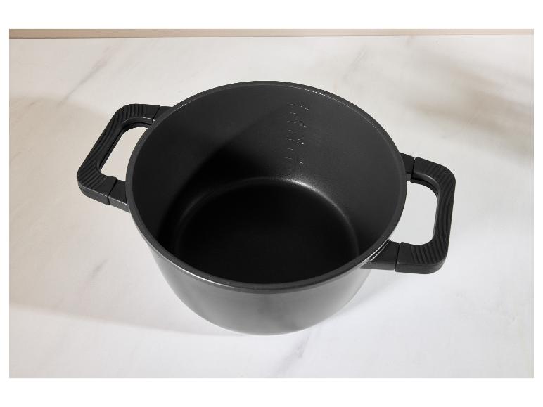 Marmite noire avec poignées et graduations sur une surface blanche