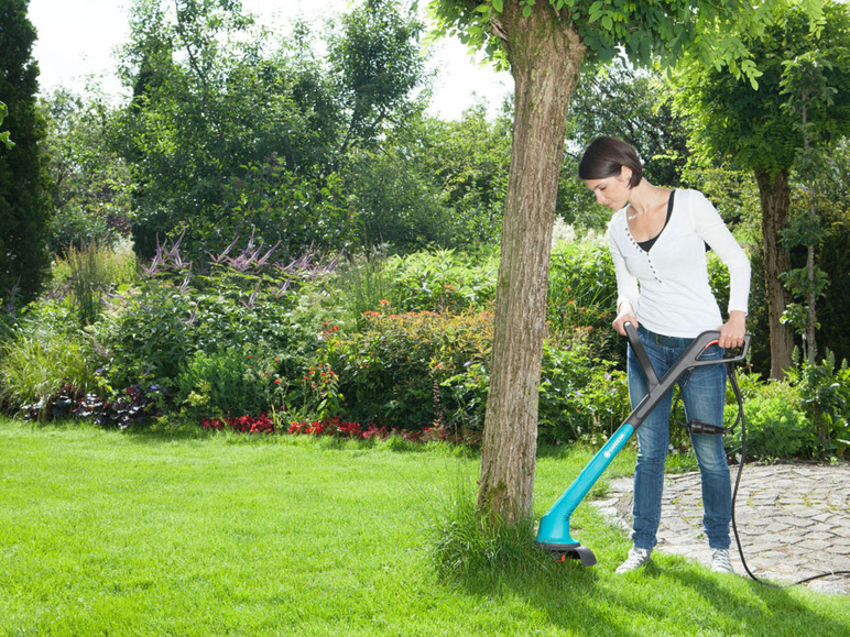 Une femme utilise une débroussailleuse Bosch pour désherber son jardin.