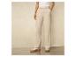 Pantalon beige avec des baskets blanches sur un sol en bois.