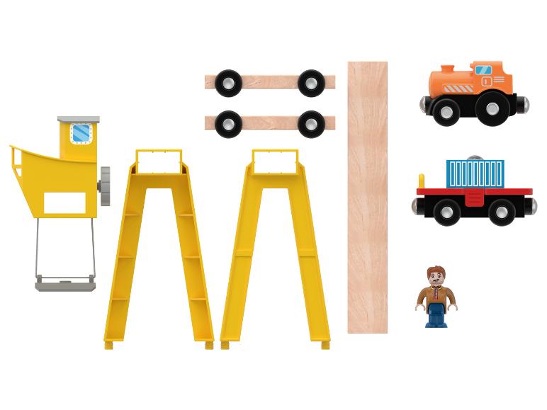 Ensemble de jouets en bois avec une grue, une locomotive et une figurine.