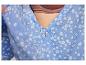 Gros plan sur une robe bleue à fleurs avec un bouton.