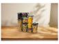 Conteneurs alimentaires transparents avec pâtes, noix et grains de café sur une table en bois.