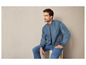 Homme en veste bomber bleue et en jean.