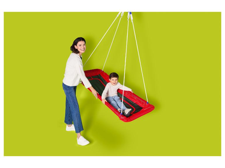 Mère et enfant sourient, l'enfant étant assis dans une balançoire rouge.