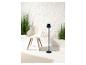 Lampe sur pied et fauteuil design moderne avec plantes vertes.