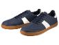 Une paire de baskets bleu marine avec des bandes blanches et des semelles en caoutchouc.