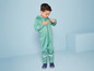 Un enfant dans une combinaison verte avec des détails réfléchissants.