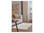 Salon confortable avec un canapé crème, une table basse ronde et un tapis clair sur un parquet.