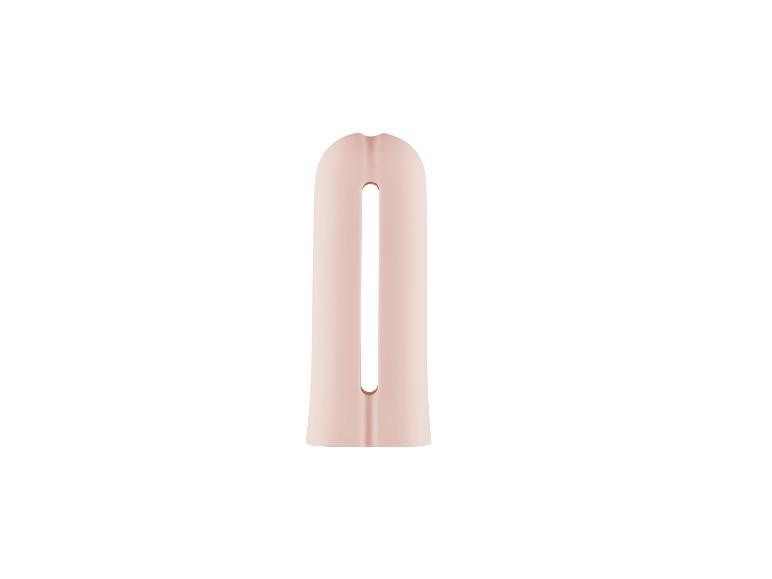 Accessoire de soin personnel rose pâle avec une ouverture centrale.