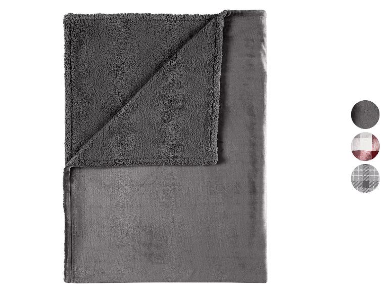 Couverture grise réversible avec un côté moelleux et un côté lisse, avec des échantillons de couleurs et de motifs.