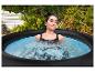 Femme se détend dans un jacuzzi extérieur, entourée de verdure.