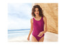 Une femme en maillot de bain rose sur la plage.