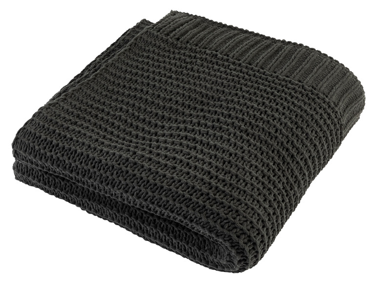 Une couverture en tricot gris foncé, pliée.