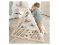 Un enfant grimpe sur une pyramide d'escalade en bois Roba.