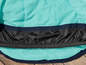 L'intérieur d'une veste bleu clair avec une doublure noire et une bordure bleu marine.