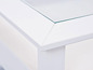 Table basse blanche avec plateau en verre.