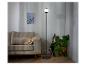 Lampe sur pied moderne avec abat-jour en verre, près d'un canapé.