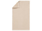 Une serviette en tissu gaufré de couleur beige.