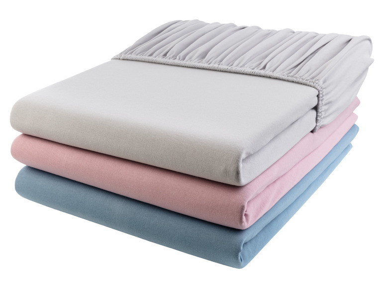 Une pile de draps en gris, rose et bleu.