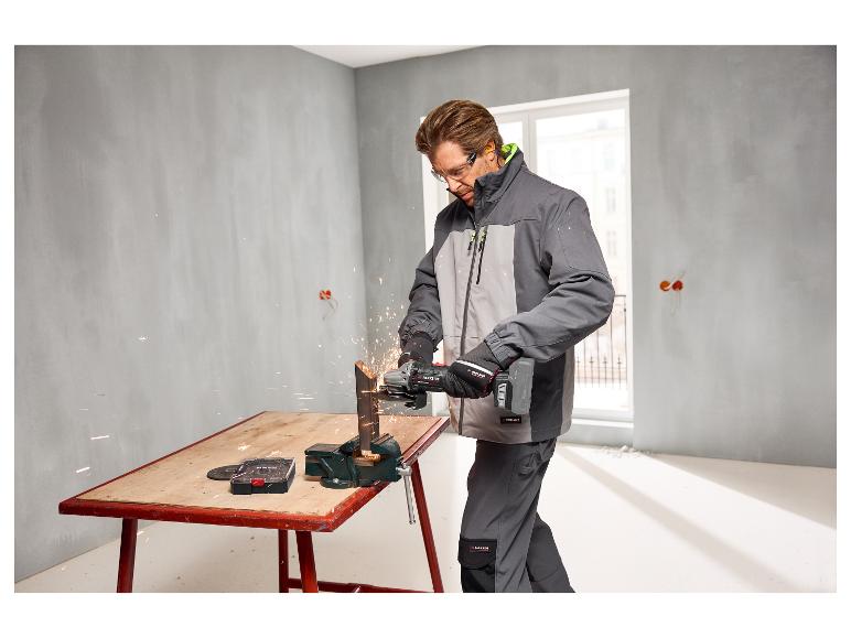 Un homme coupe un tube métallique avec un disque à tronçonner le métal PARKSIDE PERFORMANCE®.