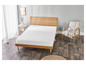 Un matelas blanc sur un cadre de lit en bois dans une chambre à coucher.