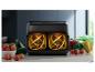 Friteuse à air Philips noire sur un comptoir de cuisine avec des légumes frais