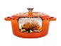 Cocotte en fonte orange avec un poulet rôti à l'intérieur.