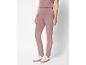 Une femme porte un pantalon rose et des baskets blanches.