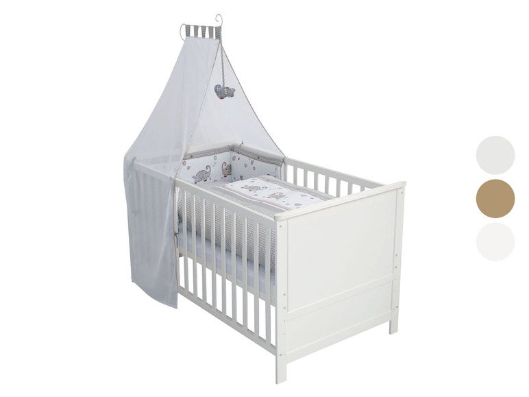 Lit bébé blanc avec ciel de lit et linge de lit à motif d'éléphants.