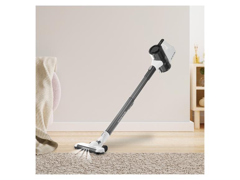 Aspirateur sans fil Invictus sur un parquet clair et un tapis beige.