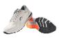 Des chaussures de course blanches avec des semelles orange et noires.