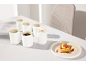 Ensemble de tasses en céramique sans anse et assiette avec dessert sur la table.