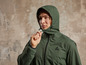 Un homme porte une veste verte à capuche.