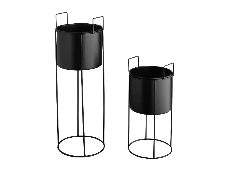 Deux supports pour plantes en métal noir avec des pots.