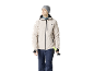 Homme en veste de ski beige, pantalon bleu foncé et bonnet gris, tenant des bâtons de ski.