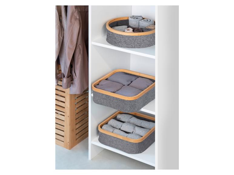 Panier de rangement gris avec bordure en bambou dans une armoire.