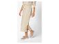 Jupe beige avec fente et baskets.