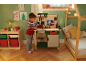 Enfant jouant avec un établi jouet dans une chambre sur le thème de Noël.