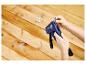 Personne chargeant l'agrafeuse manuelle LIVARNO® Handtacker »RPC7« avec des agrafes sur fond en bois.