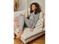 Une femme porte un pyjama gris avec l'inscription 'Natural Beauty'.
