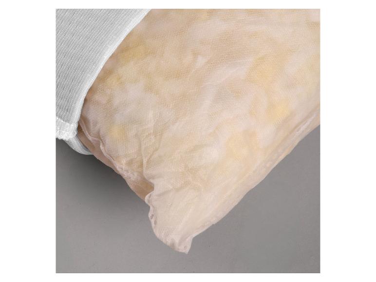 Gros plan d'un oreiller avec une housse en maille beige clair et un bord en tissu blanc.